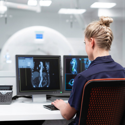 Eine Frau schaut MRI Bilder auf einem Computer an