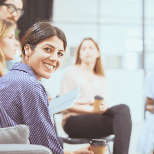 Eine lächelnde Frau schaut direkt in die Kamera.
