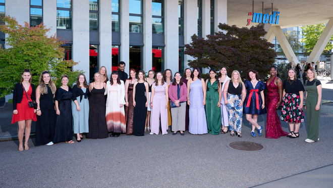 Gruppe festlich gekleideter Personen stellt sich vor dem medi-Gebäude für ein gemeinsames Foto auf.